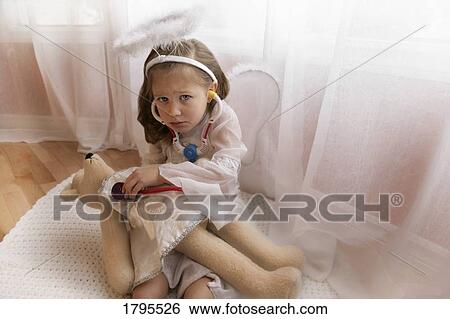Stock Photograph - Child upset about teddy bear's prognosis. Fotosearch
