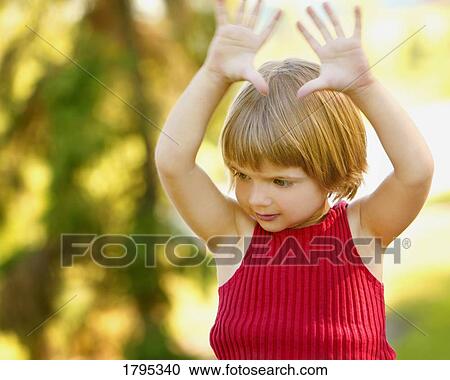 Stock Image - Girl with her arms in the air. Fotosearch