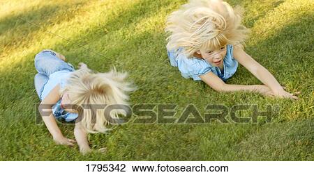 Girls rolling down a hill View Large Photo Image Stock Image - Girls rolling down a hill. Fotosearch