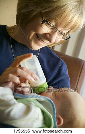 Grandma feeding grandchild View Large Photo Image Stock Photograph - Grandma feeding grandchild. Fotosearch