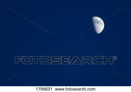 Stock Image - Half moon against deep blue sky. Fotosearch