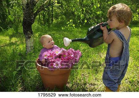 Junior gardener watering "flowers" View Large Photo Image Stock Photo - Junior gardener watering "flowers". Fotosearch