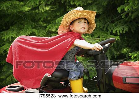 Stock Image - Little boy pretending to ride lawn tractor. Fotosearch