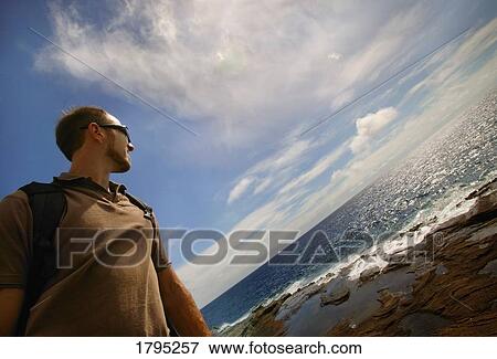 Man walking along shore View Large Photo Image Stock Photo - Man walking along shore. Fotosearch
