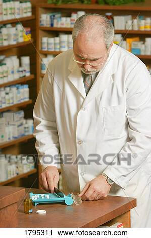 Stock Image - Pharmacist filling prescription. Fotosearch