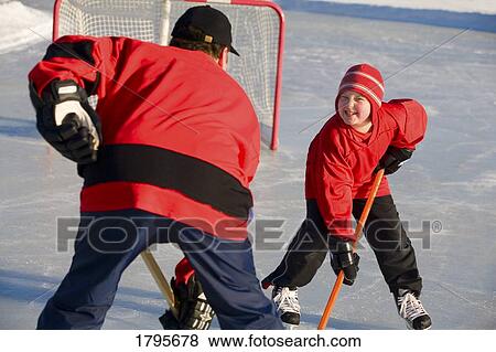 Stock Photo - Playing hockey. Fotosearch