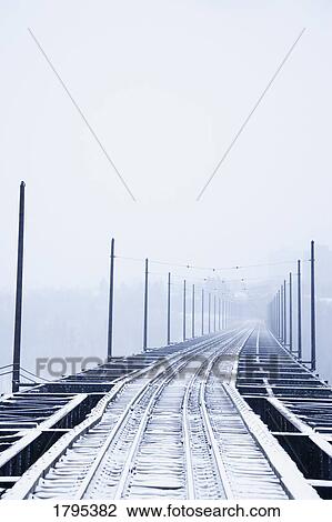 Stock Image - Snow covered train tracks. Fotosearch