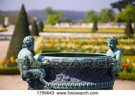 Stock Image - Statues and Fountain in flower garden, Château Versailles, France. Fotosearch
