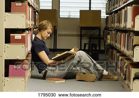 Stock Image - Student in a library. Fotosearch