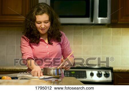 Stock Image - Teenager cooking food. Fotosearch