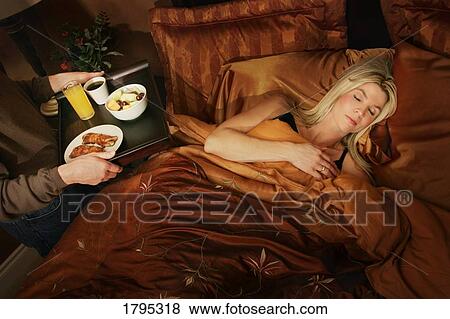 Stock Photo - Woman getting breakfast in bed. Fotosearch