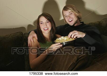 Stock Photo - Young couple watching a movie together. Fotosearch
