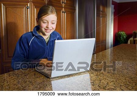 Stock Photo - Young girl working on laptop. Fotosearch