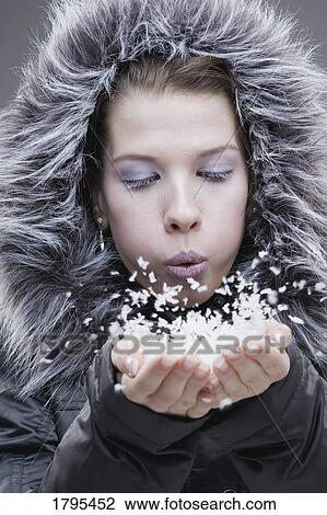 Young woman in fur lined jacket, breathing onto a handful of snow View Large Photo Image Stock Image - Young woman in fur lined jacket, breathing onto a handful of snow. Fotosearch