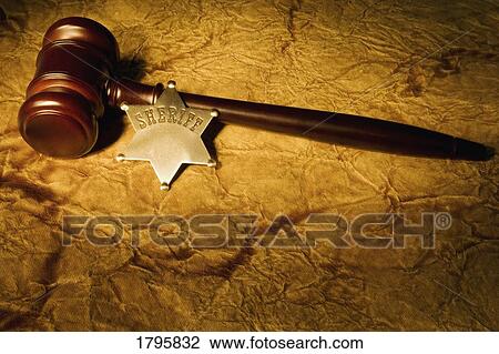 Stock Image - A wooden gavel and Sheriff's badge. Fotosearch