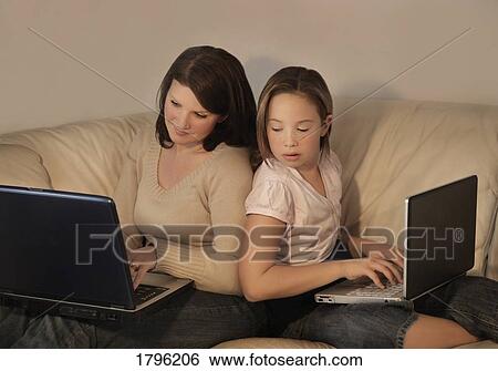 Stock Photograph - Mother and daughter working on laptops. Fotosearch