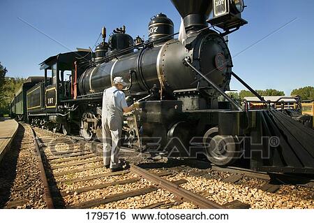 Stock Photograph - Old-fashioned train and conductor. Fotosearch