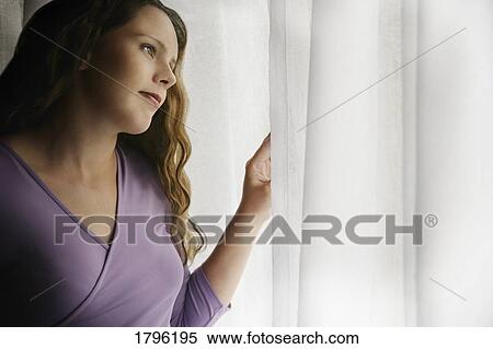 Stock Photography - Woman looking out the window. Fotosearch