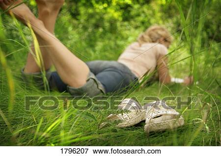 Stock Photo - Woman lying in the grass. Fotosearch