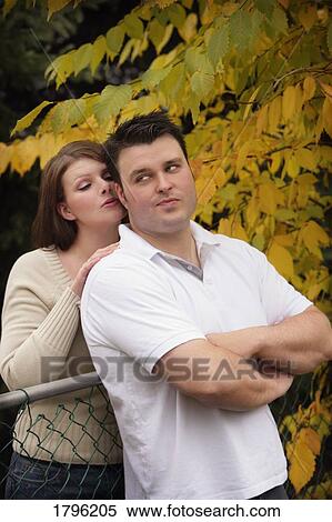 Stock Photography - Woman whispering into a man's ear. Fotosearch