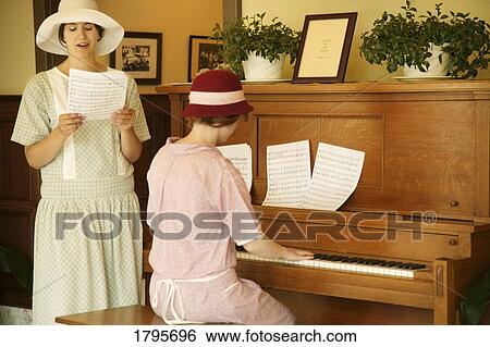 Stock Photograph - Women playing piano and singing. Fotosearch