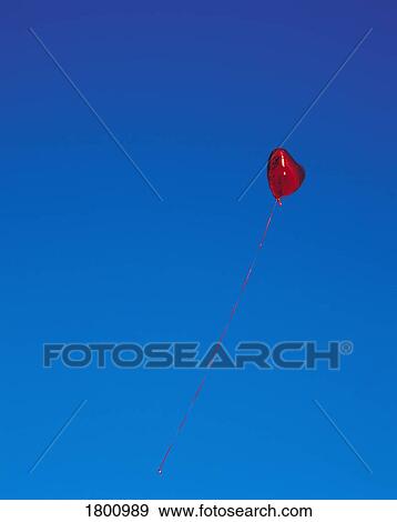 Stock Photo - A heart-shaped balloon in the sky. Fotosearch