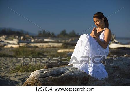 A young woman praying on the beach View Large Photo Image Picture - A young woman praying on the beach. Fotosearch