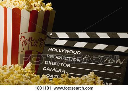 Stock Image - Action movie clapboard with popcorn. Fotosearch