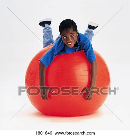Stock Photograph - Boy balancing on exercise ball. Fotosearch