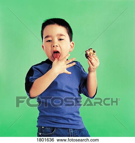 Boy eating a cookie View Large Photo Image Stock Photograph - Boy eating a cookie. Fotosearch