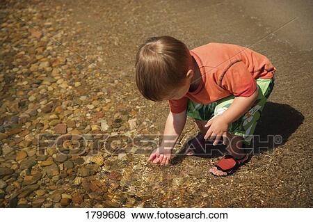 Boy playing in the water View Large Photo Image Stock Photo - Boy playing in the water. Fotosearch