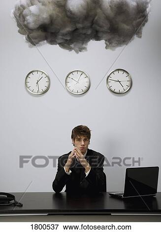 Stock Photo - Businessman in office under cloud. Fotosearch