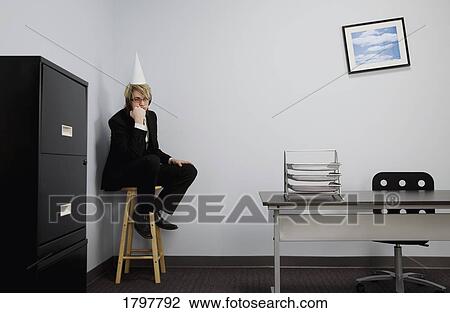 Stock Image - Businessman wearing a dunce cap. Fotosearch