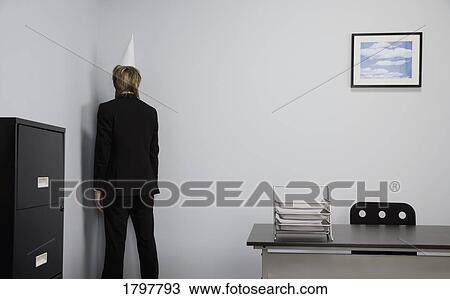 Stock Image - Businessman wearing a dunce cap. Fotosearch