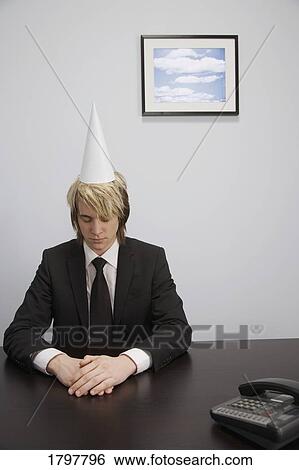 Stock Photograph - Businessman wearing a dunce cap. Fotosearch