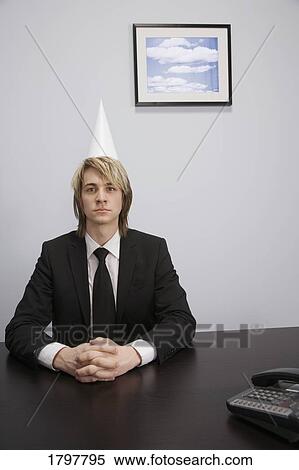 Businessman wearing a dunce cap View Large Photo Image Stock Photography - Businessman wearing a dunce cap. Fotosearch
