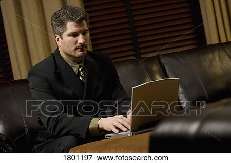 Stock Photo - Businessman working on laptop on the coffee table. Fotosearch