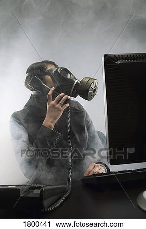 Stock Image - Businessperson wearing gas mask in smokey office. Fotosearch