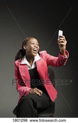 Stock Photo - Businesswoman laughing at her cell phone. Fotosearch