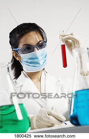 Stock Photography - Chemist looking at beaker. Fotosearch