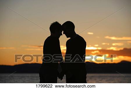 Stock Image - Couple standing by the water. Fotosearch