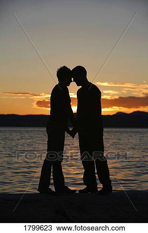 Stock Image - Couple standing by the water. Fotosearch