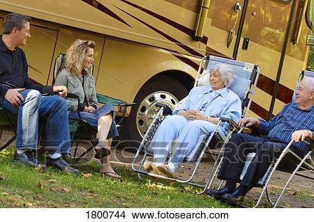 Couples siting on lawn chairs outside motor home View Large Photo Image Picture - Couples siting on lawn chairs outside motor home. Fotosearch