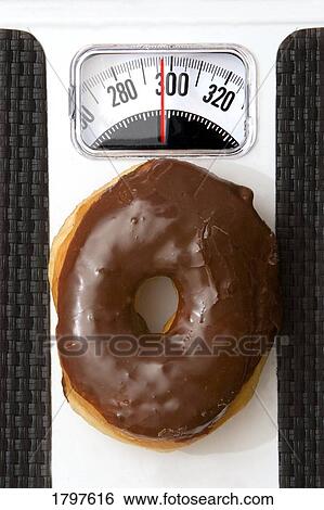 Donut tipping the scale View Large Photo Image Stock Photograph - Donut tipping the scale. Fotosearch
