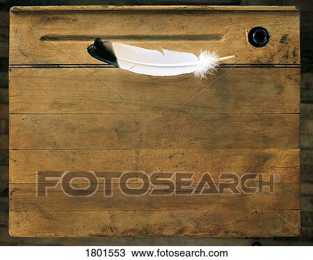 Stock Image - Feather pen on an antique desk . Fotosearch