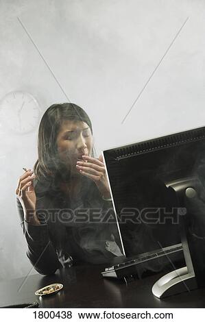 Stock Photo - Female smoking in office. Fotosearch