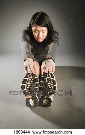 Picture - Female stretching leg muscles. Fotosearch