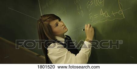 Female student in uniform writing on chalkboard View Large Photo Image Stock Image - Female student in uniform writing on chalkboard. Fotosearch