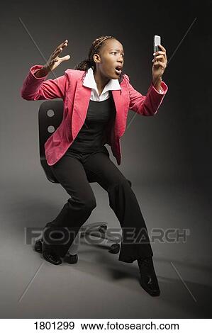 Stock Photo - Girl exclaiming over cell phone. Fotosearch