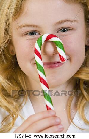 Girl holding a candy cane View Large Photo Image Stock Photography - Girl holding a candy cane. Fotosearch